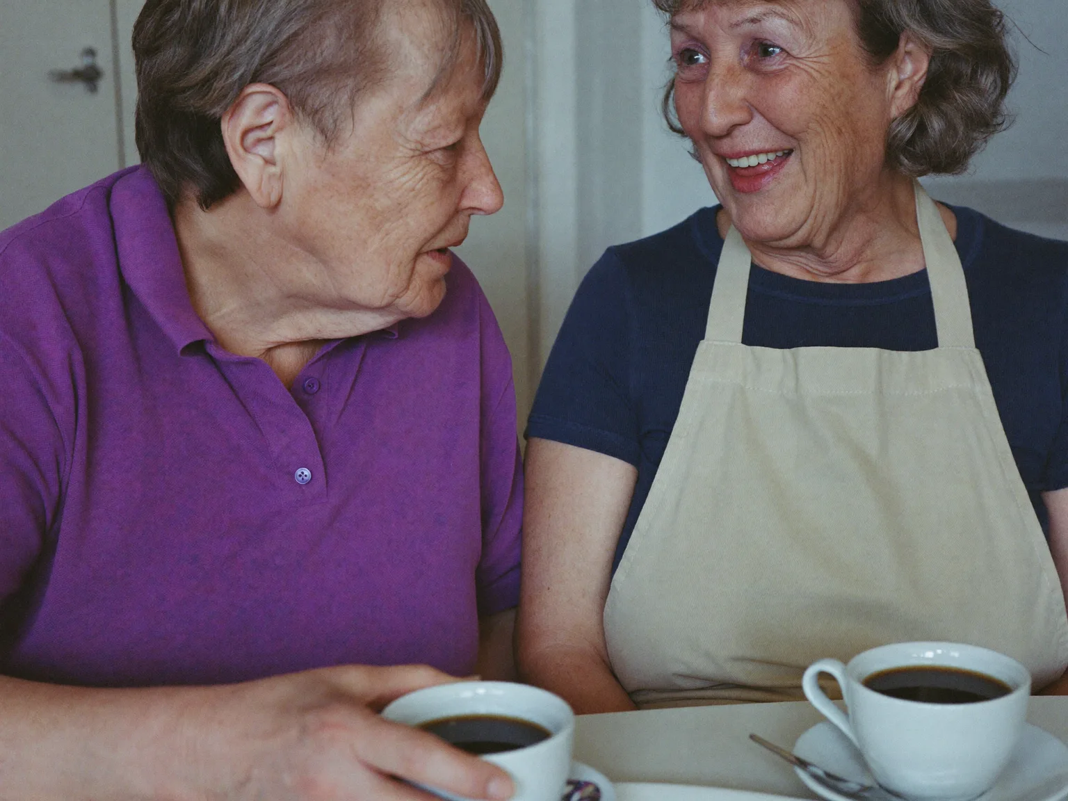 Haushaltshilfe und Seniorin trinken zusammen Kaffee am Tisch in Ehningen