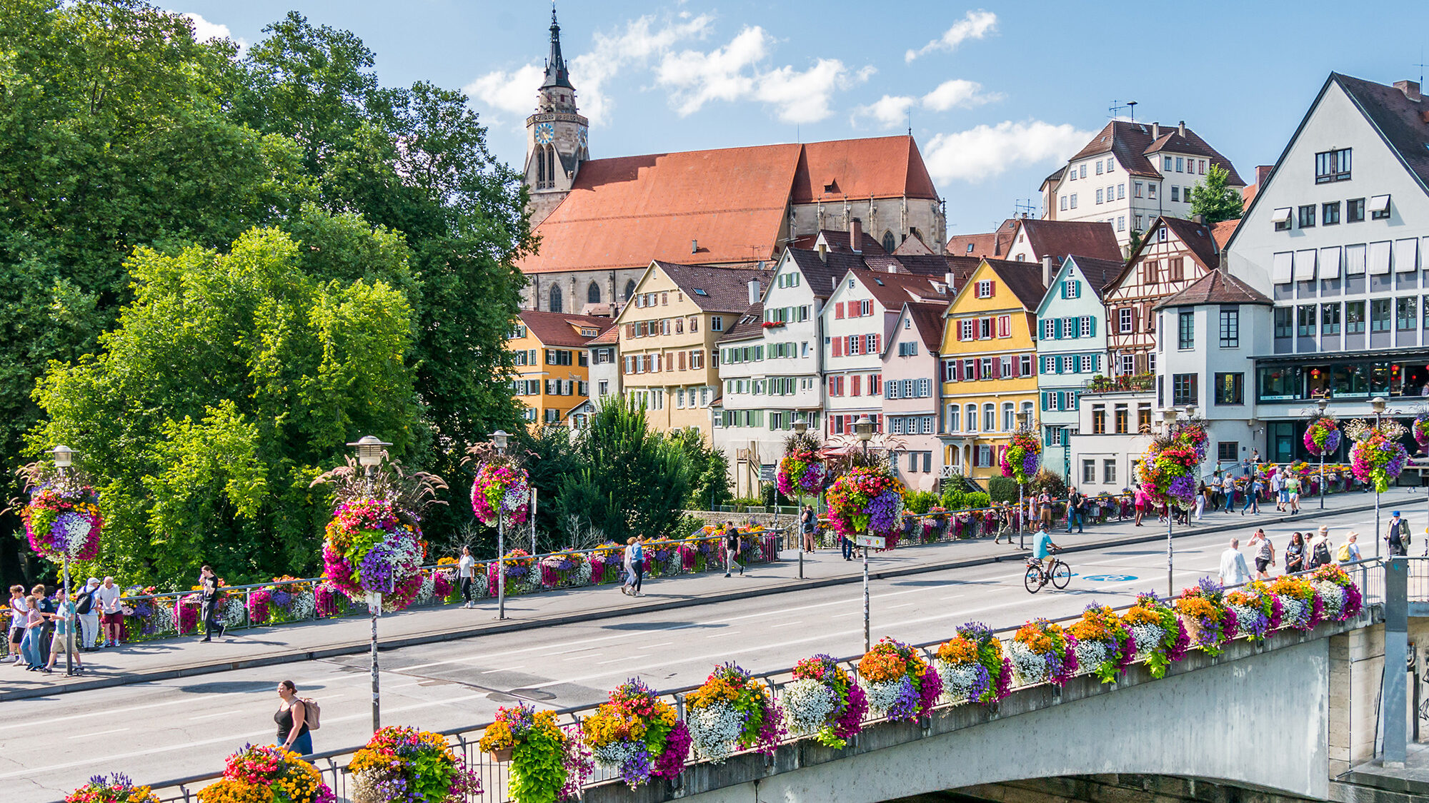 Blumen geschmückte Neckarbrücke in Tübingen mit Blick auf die Altstadt und Stiftskirche